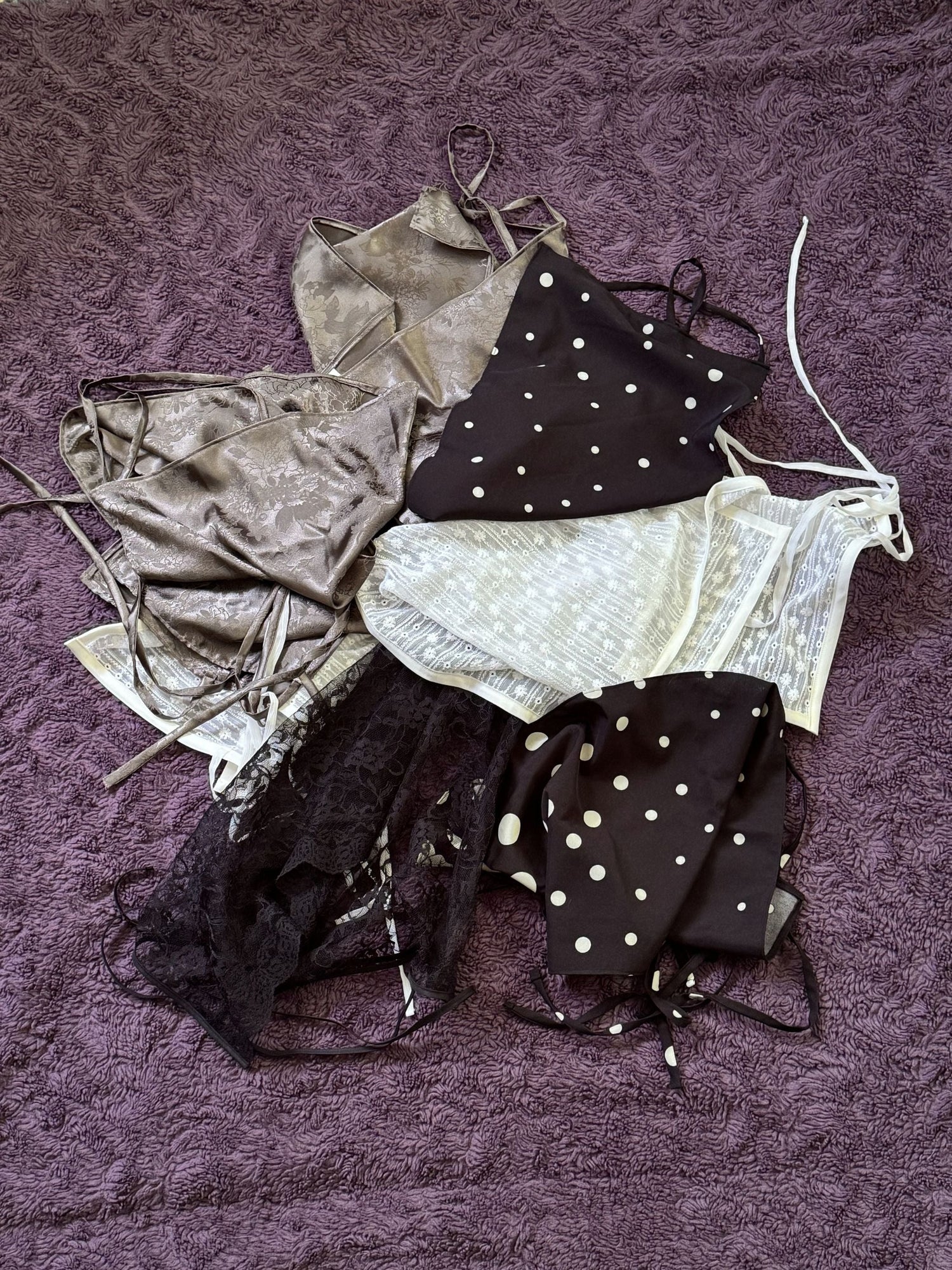 Pile of different skirts on a purple blanket.