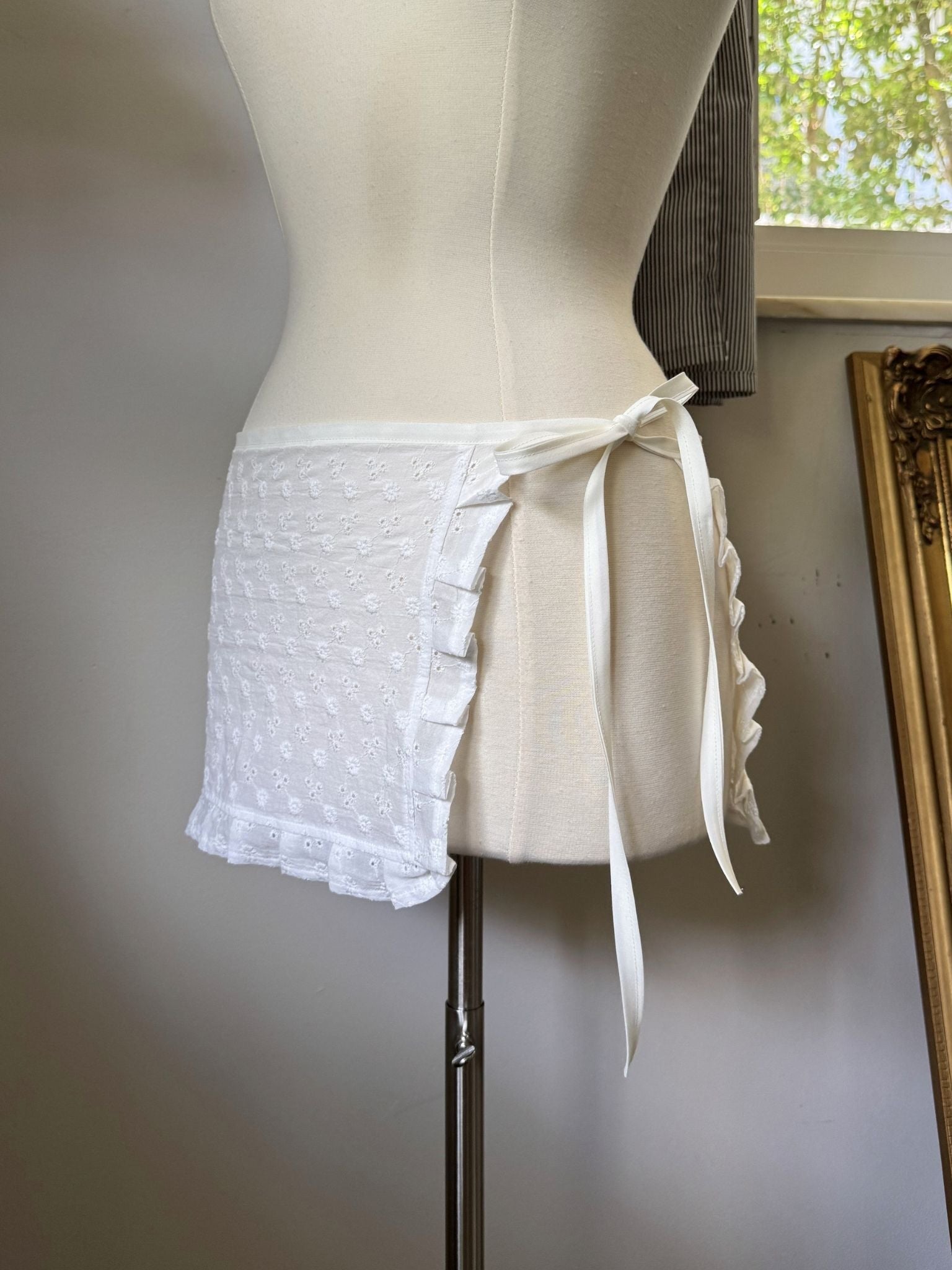 White lace skirt on a mannequin against a neutral background