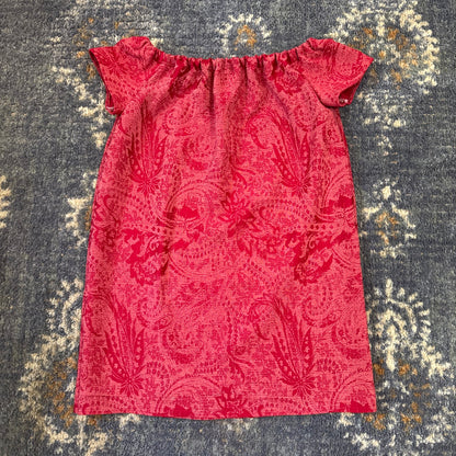 Red patterned dress on blue rug.